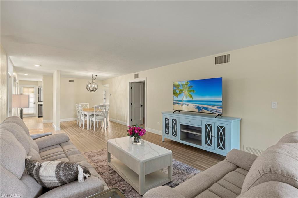 3101 Riviera Drive Naples, FL 34103 - Photo 3 of 41 a living room with furniture a flat screen tv and a fireplace