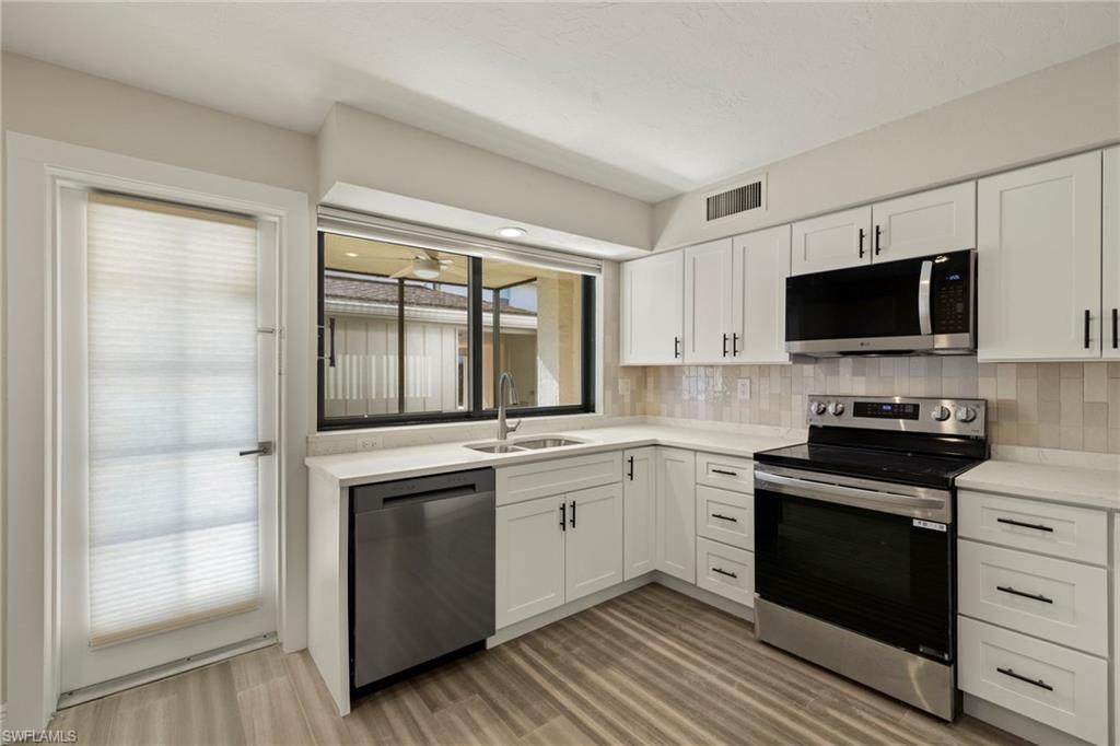 3101 Riviera Drive Naples, FL 34103 - Photo 9 of 41 a kitchen with a stove and a sink
