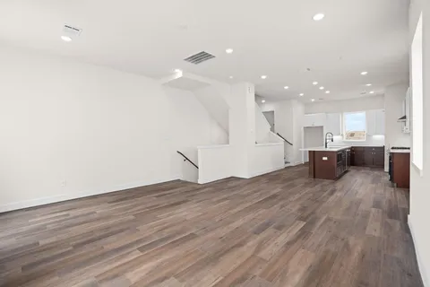 a large kitchen with stainless steel appliances granite countertop a lot of counter space and wooden floors