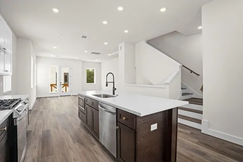 a kitchen with a sink cabinets and wooden floor