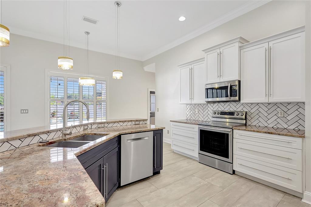 2863 Duncan Tree Circle Valrico, FL 33594 - Photo 24 of 53 a large white kitchen with stainless steel appliances granite countertop a stove and a sink