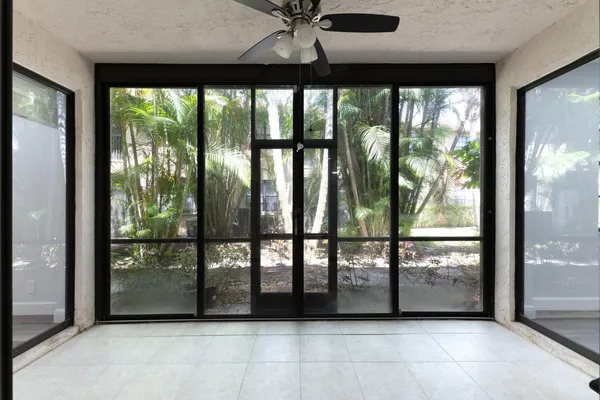 an empty room with wooden floor and a ceiling fan