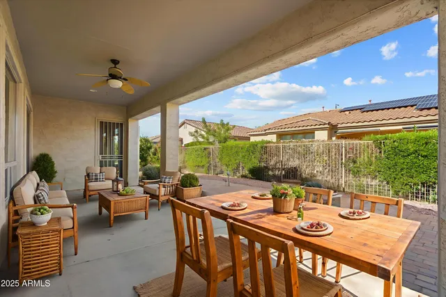 a dining room with furniture a chandelier and a large window