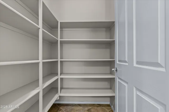 a view of walk in closet with empty racks