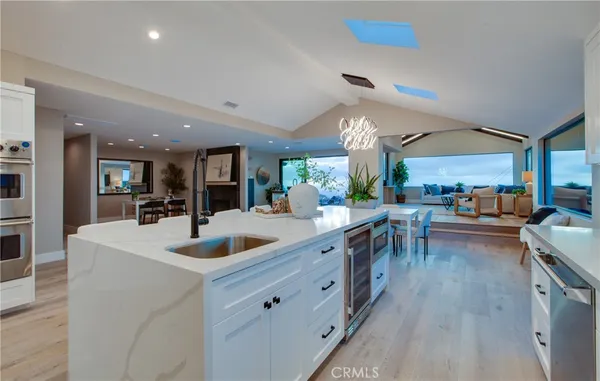 a kitchen with kitchen island granite countertop a sink cabinets and stainless steel appliances