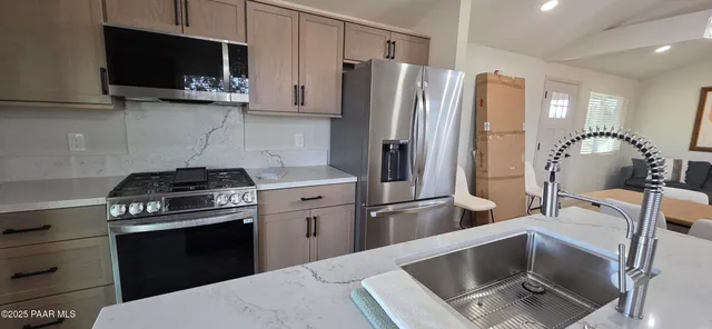 a kitchen with stainless steel appliances a refrigerator stove and microwave