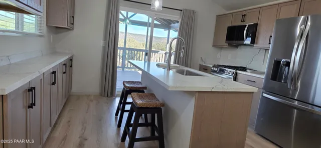 a kitchen with kitchen island a large counter top space appliances and furniture