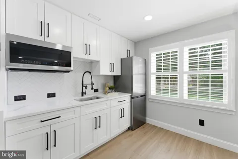 a kitchen with a sink a window and cabinets