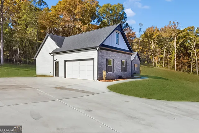a front view of a house with a garden and trees