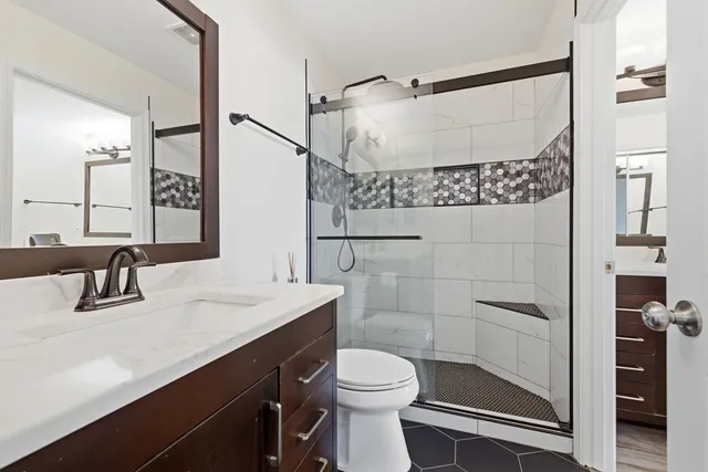 a bathroom with a sink a toilet and shower