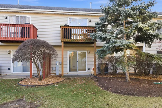 a view of a house with a yard and a large tree
