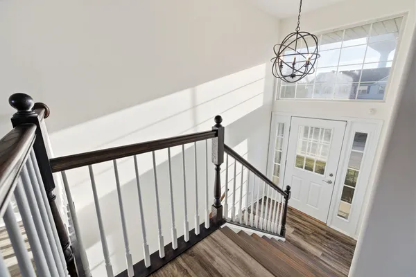 a view of staircase with wooden floor and fan