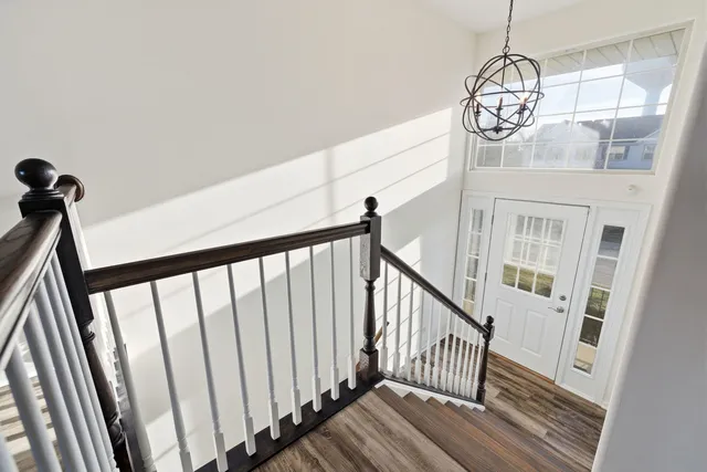 a view of staircase with wooden floor and fan