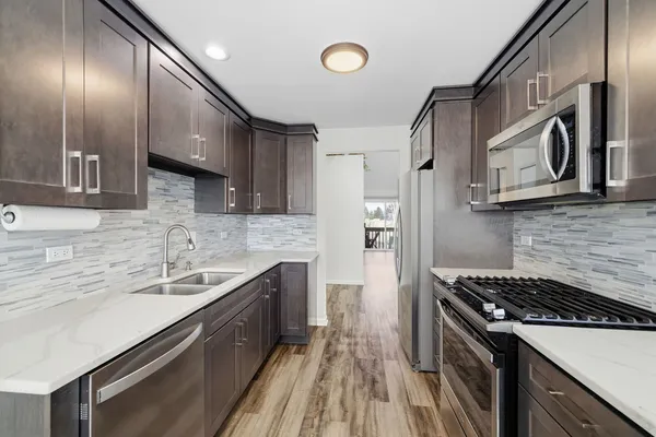 a kitchen with stainless steel appliances a sink stove and cabinets