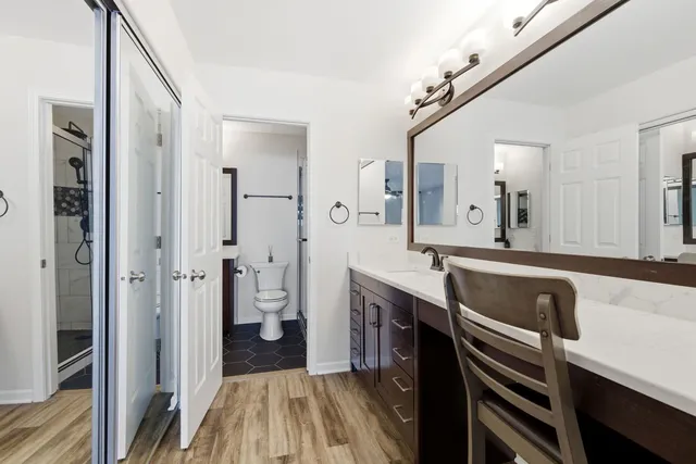 a bathroom with a sink a toilet and shower