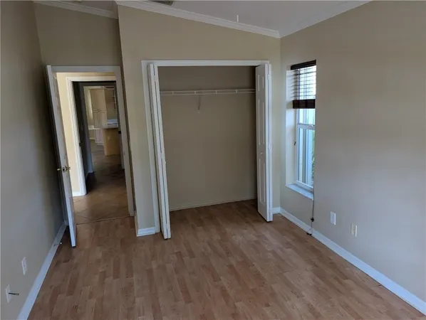 an empty room with wooden floor and closet