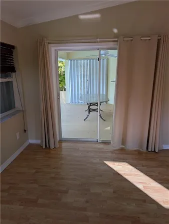 an empty room with wooden floor and a window
