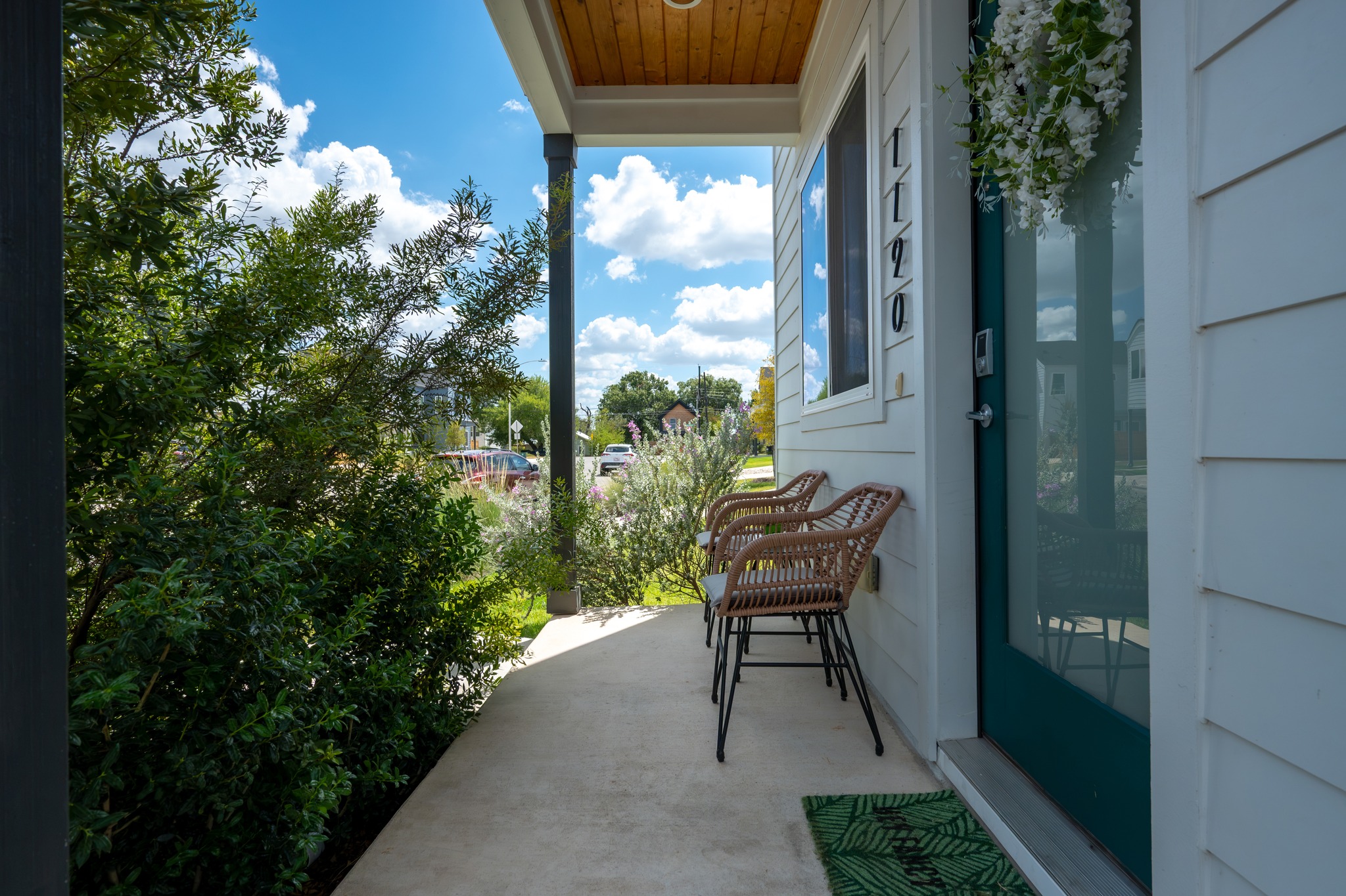1190 Sarabeth Way Austin, TX 78721 - Photo 2 of 22 A welcoming covered front porch features a wood paneled ceiling and clean concrete flooring.