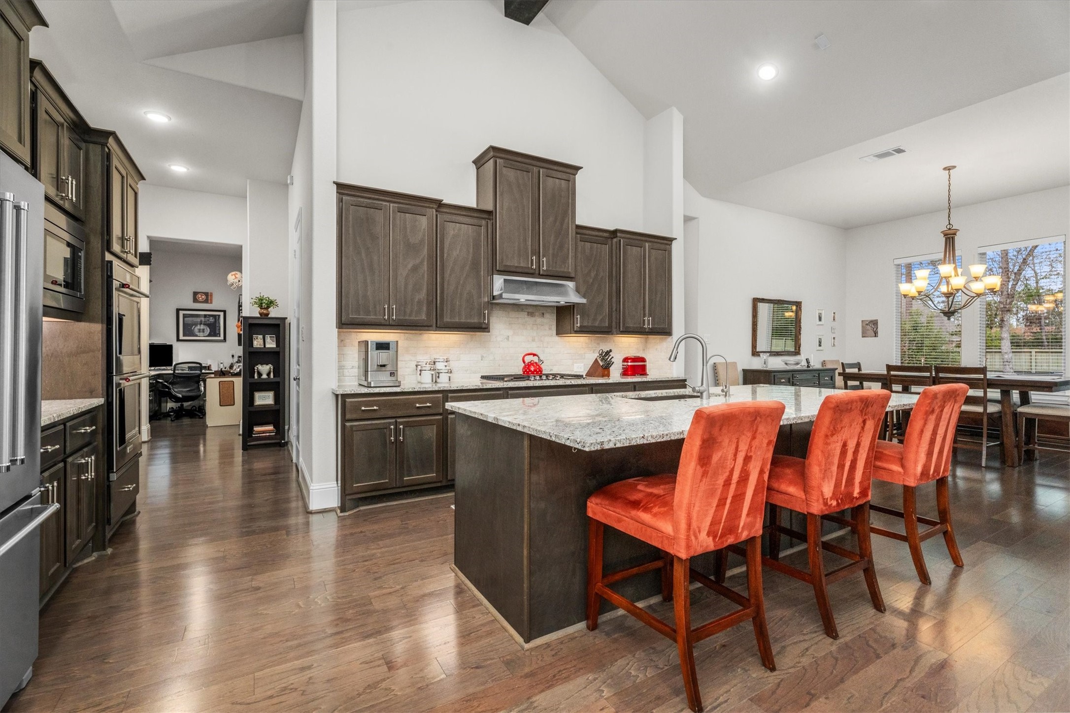 106 Amber Jade Court Conroe, TX 77304 - Photo 12 of 50 a kitchen with stainless steel appliances kitchen island granite countertop a refrigerator a stove a sink dishwasher and a dining table with wooden floor