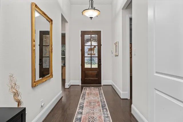 a view of a hallway with wooden floor and furniture