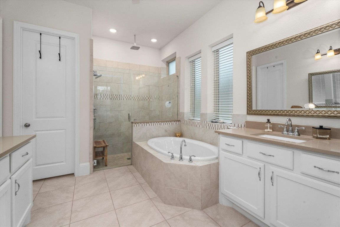 106 Amber Jade Court Conroe, TX 77304 - Photo 31 of 50 a bathroom with a tub sink and mirror