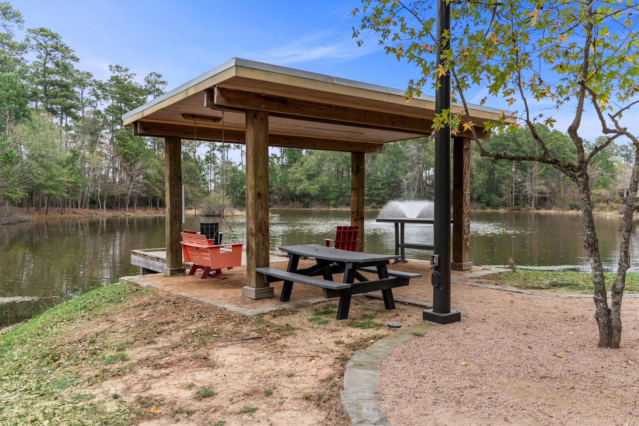 106 Amber Jade Court Conroe, TX 77304 - Photo 43 of 50 a view of a lake with a table and chairs under an umbrella