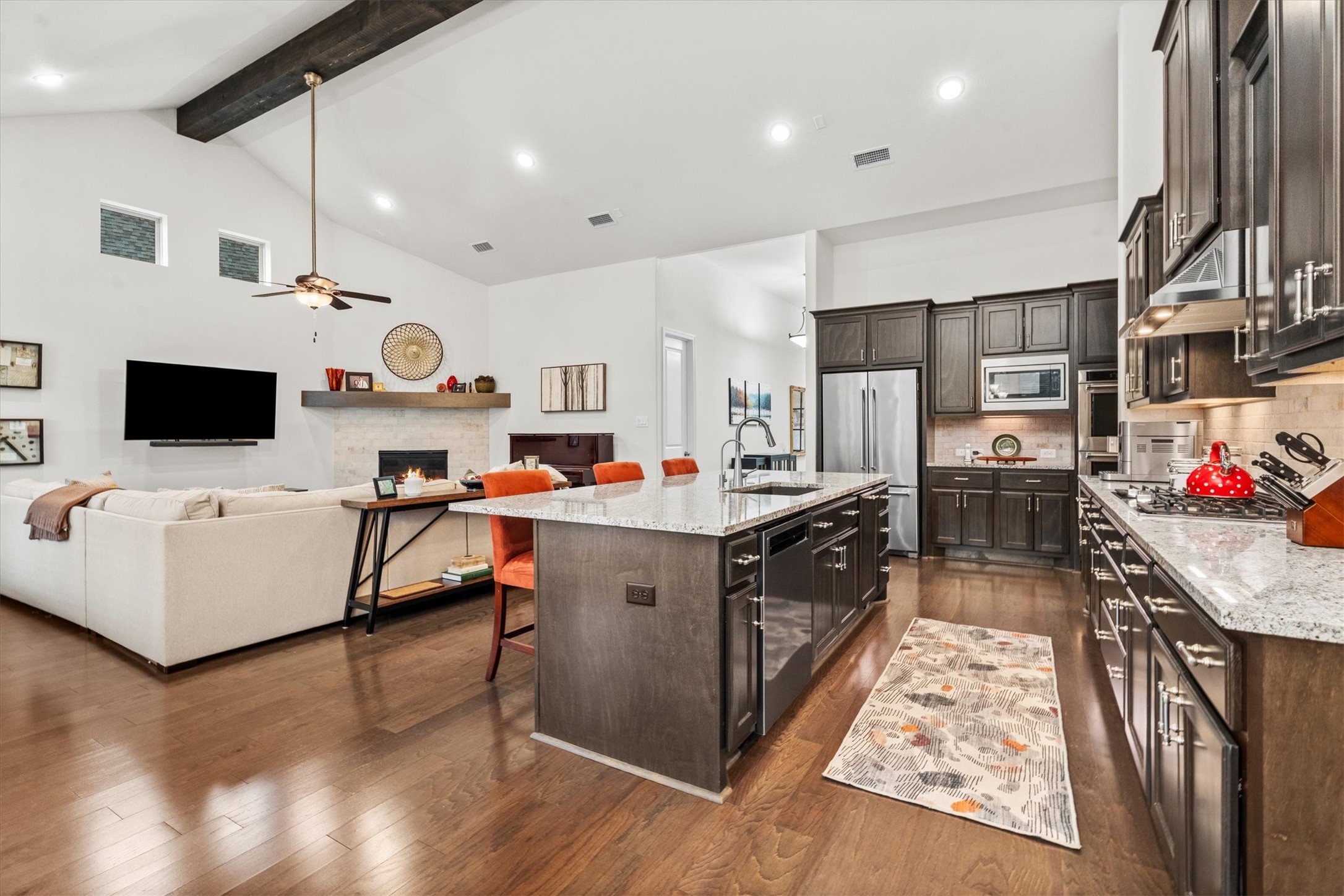 106 Amber Jade Court Conroe, TX 77304 - Photo 7 of 50 a large white kitchen with stainless steel appliances kitchen island granite countertop a table chairs and a wooden floors
