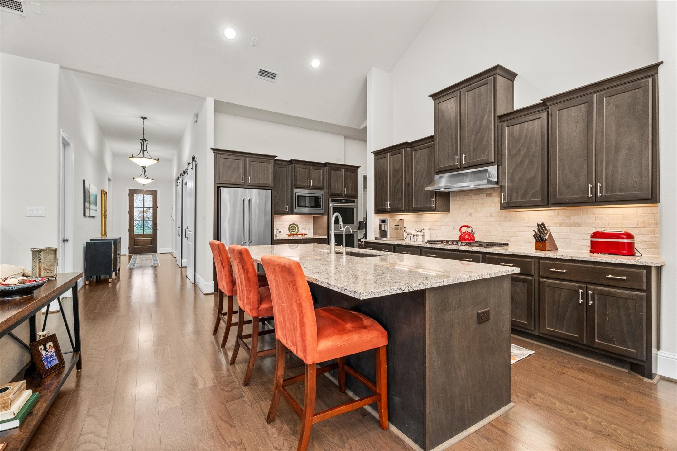 106 Amber Jade Court Conroe, TX 77304 - Photo 9 of 50 a kitchen with granite countertop a dining table chairs sink and cabinets