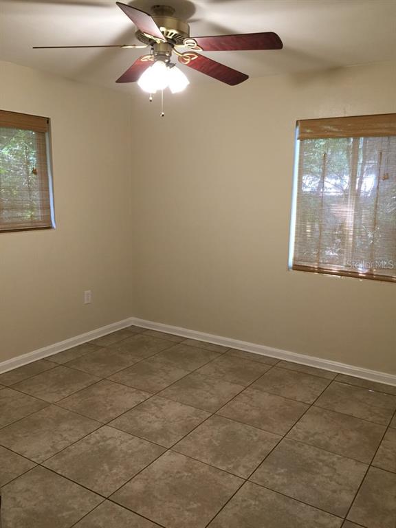631 Northwest 34th Terrace Gainesville, FL 32607 - Photo 10 of 14 an empty room with windows and fan