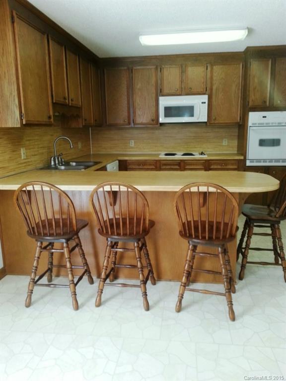 205 Timberfield Trail, Unit 76 China Grove, NC 28023 - Photo 3 of 8 a kitchen with a table chairs and a refrigerator