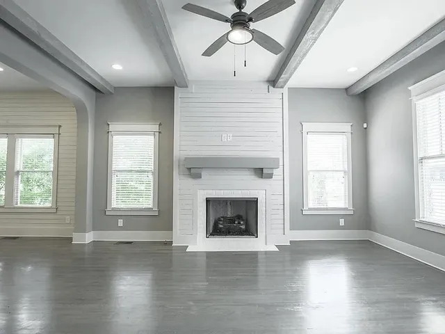 wooden floor fireplace and windows in an empty room