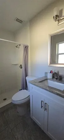 a bathroom with a granite countertop sink toilet and shower
