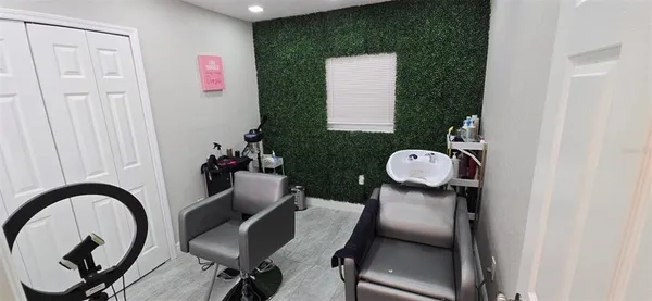 a view of a workspace room with furniture and mirror