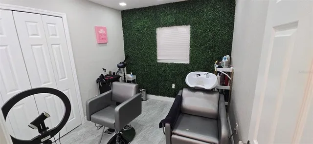 a view of a workspace room with furniture and mirror