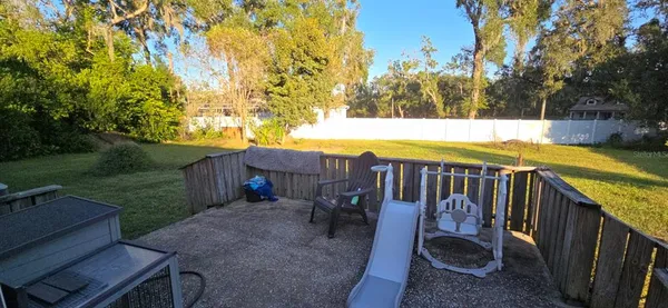 a view of a swimming pool with a patio and a yard