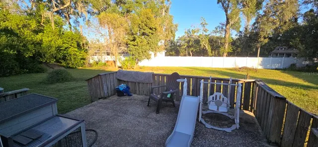 a view of a swimming pool with a patio and a yard
