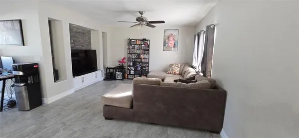 a living room with furniture and a ceiling fan