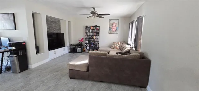 a living room with furniture and a ceiling fan