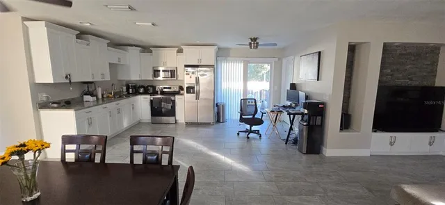 a kitchen with stainless steel appliances kitchen island granite countertop a refrigerator and microwave