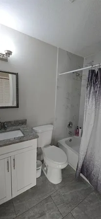 a bathroom with a granite countertop sink toilet and shower
