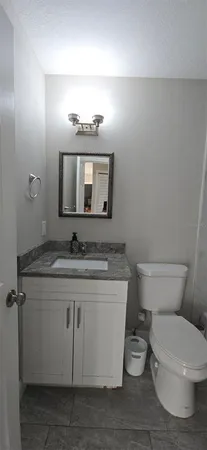 a bathroom with a toilet sink and mirror