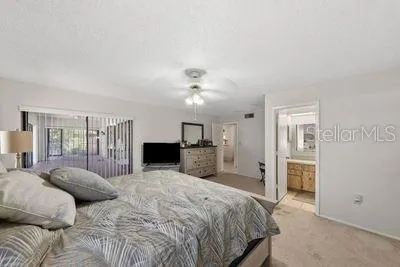 a spacious bedroom with a large bed and a chandelier