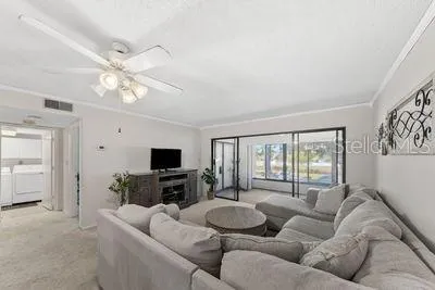 a living room with furniture a flat screen tv and a large window