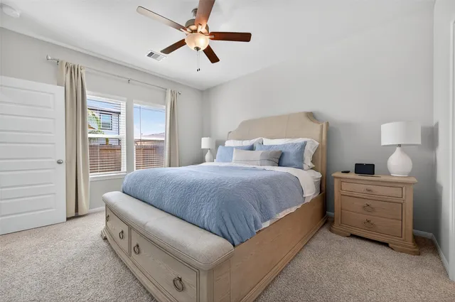 a bed room with a bed and a ceiling fan
