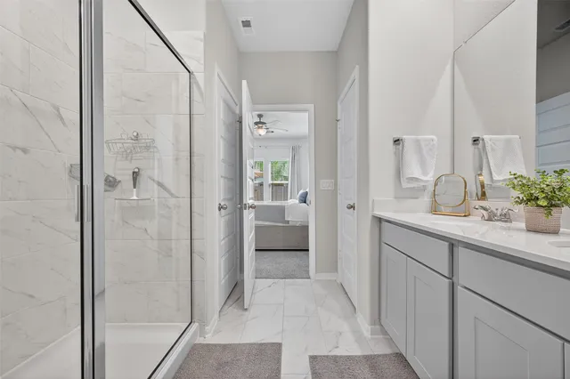 a bathroom with a granite countertop sink a toilet and shower