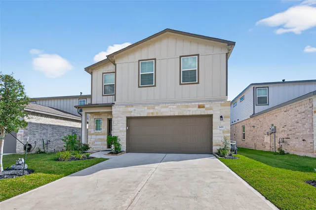 a front view of a house with a yard and garage
