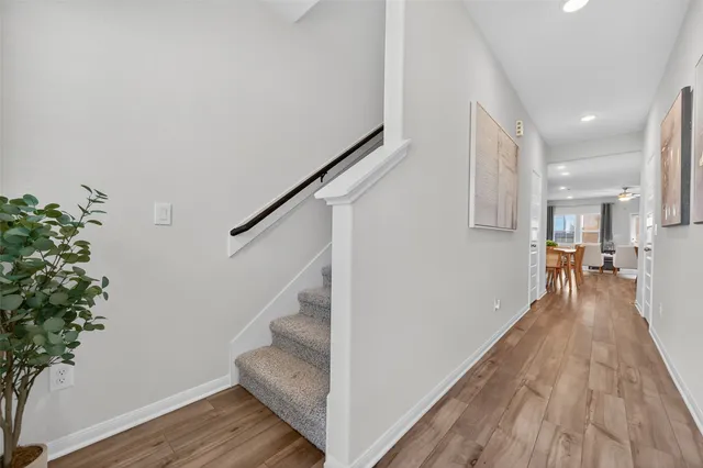 a view of a hallway with wooden floor and staircase