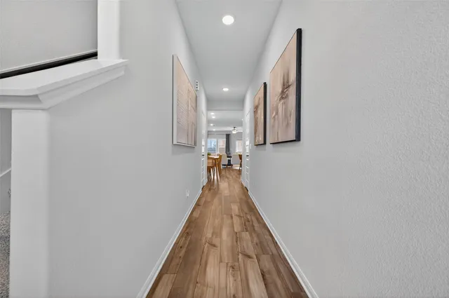 a view of a hallway with wooden floor and staircase