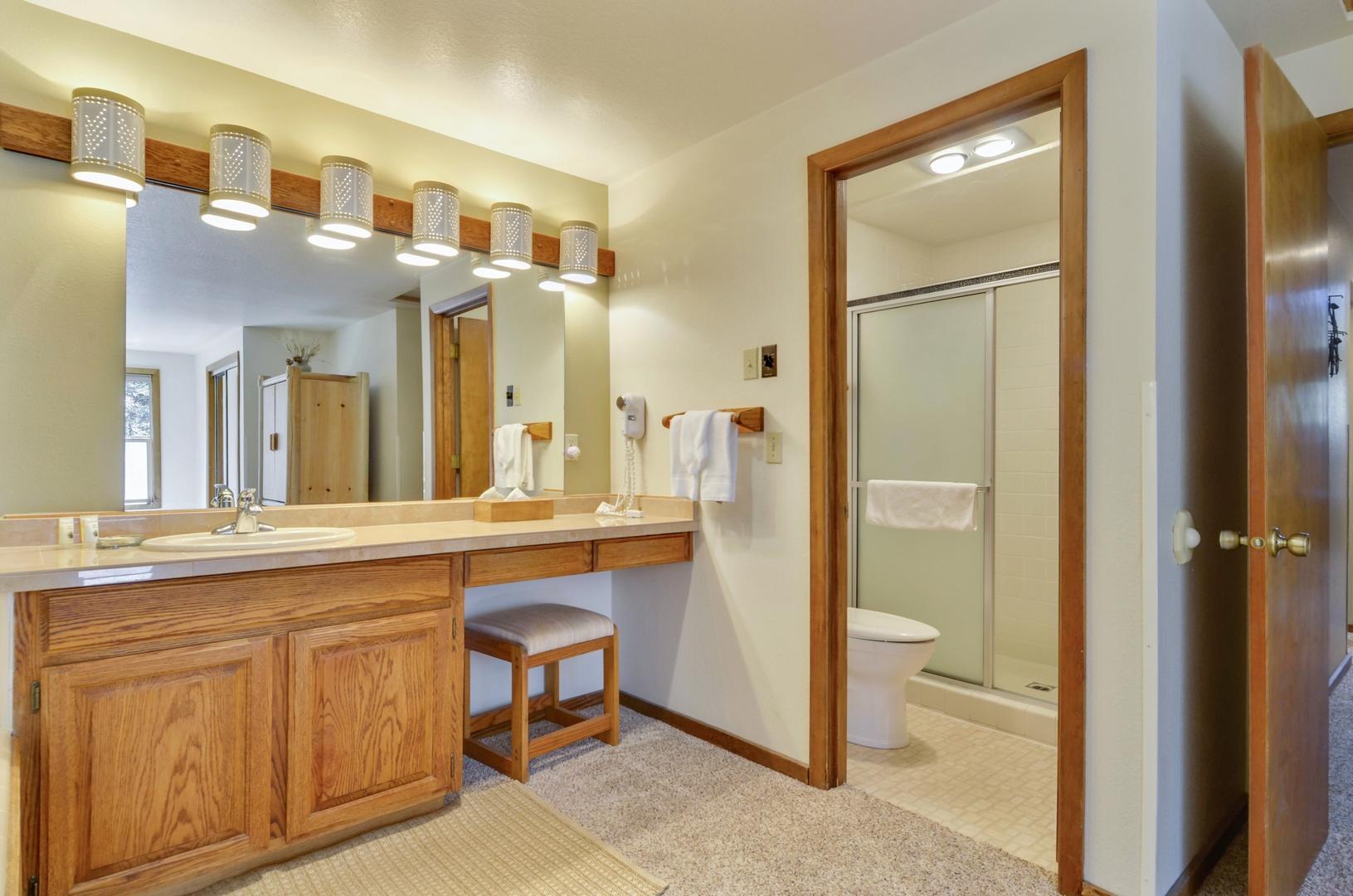 57301 Beaver Ridge Loop, Unit 10 Sunriver, OR 97707 - Photo 12 of 23 a spacious bathroom with a granite countertop sink a mirror and a shower