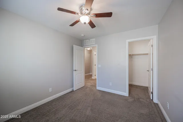 an empty room with ceiling fan and window